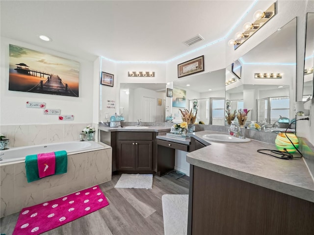 full bathroom with vanity, wood finished floors, visible vents, a shower stall, and a bath