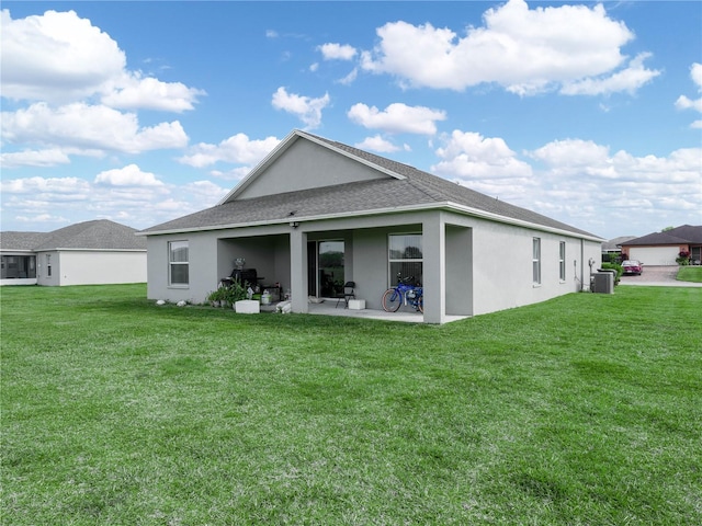 rear view of property with a patio, a lawn, and stucco siding