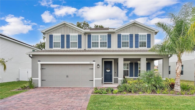 view of front of house featuring a garage, stucco siding, decorative driveway, and a front lawn