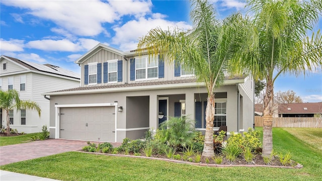 view of front facade featuring a front lawn, decorative driveway, a garage, and stucco siding