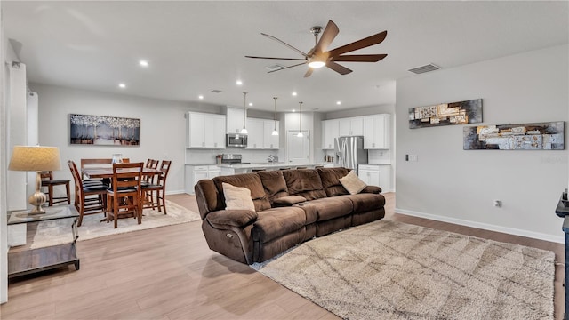 living room with visible vents, baseboards, light wood-type flooring, recessed lighting, and a ceiling fan