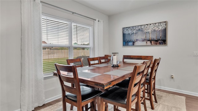 dining area featuring baseboards and light wood finished floors