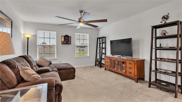 living room featuring light carpet, baseboards, and ceiling fan