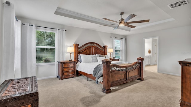 bedroom with visible vents, a raised ceiling, and multiple windows