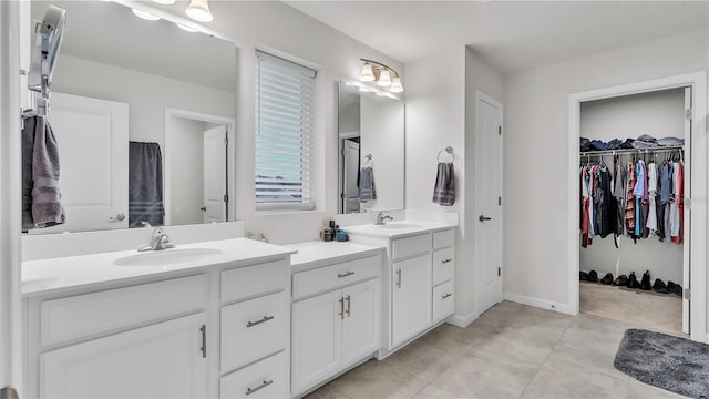 full bath with vanity, tile patterned floors, a spacious closet, and baseboards