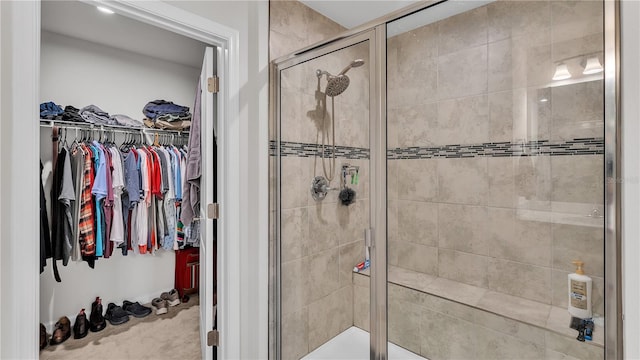 bathroom featuring a walk in closet and a shower stall