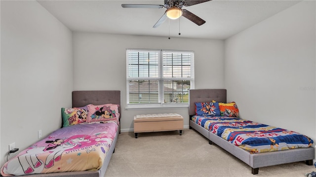 carpeted bedroom with a ceiling fan and baseboards