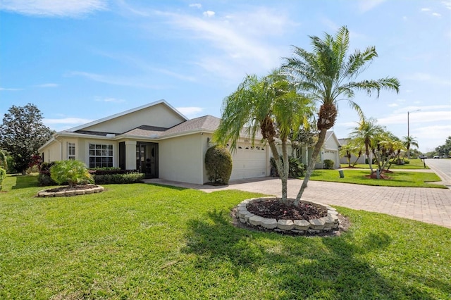 single story home featuring stucco siding, decorative driveway, a front yard, and an attached garage