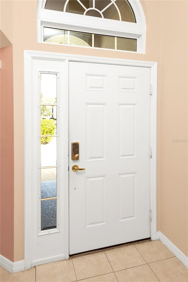 foyer featuring light tile patterned floors and baseboards