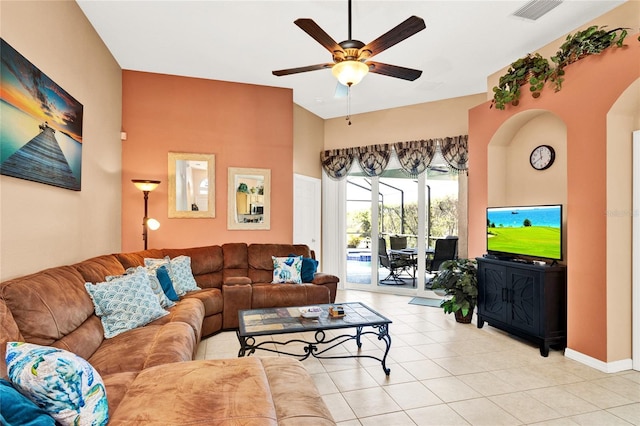 living room featuring light tile patterned floors, visible vents, baseboards, and a ceiling fan