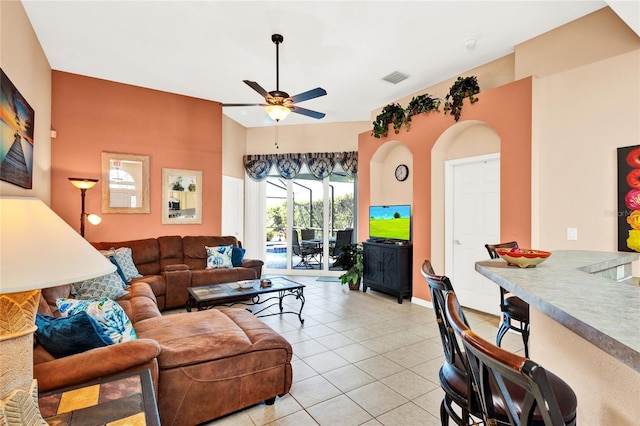 living room with light tile patterned floors, visible vents, and ceiling fan