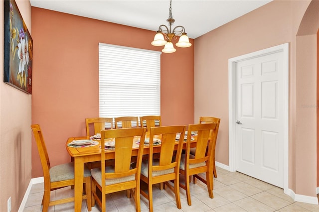 dining area with an inviting chandelier, light tile patterned flooring, and baseboards