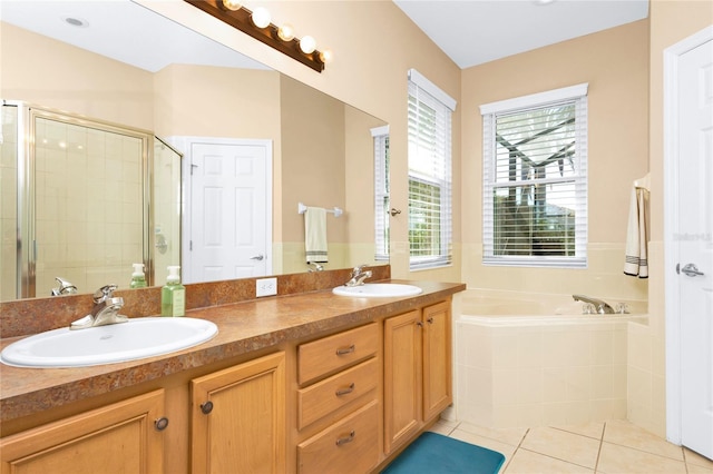 full bathroom with tile patterned flooring, a garden tub, a stall shower, and a sink