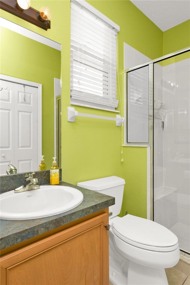 full bath with vanity, a shower stall, toilet, and tile patterned flooring