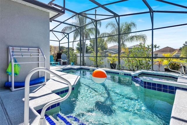 view of swimming pool featuring a pool with connected hot tub, a lanai, and a patio area