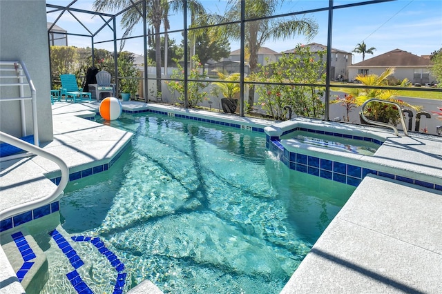 view of swimming pool featuring a patio, a pool with connected hot tub, and a lanai