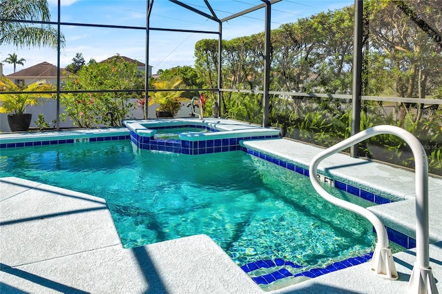 view of pool featuring a lanai, a pool with connected hot tub, and a patio