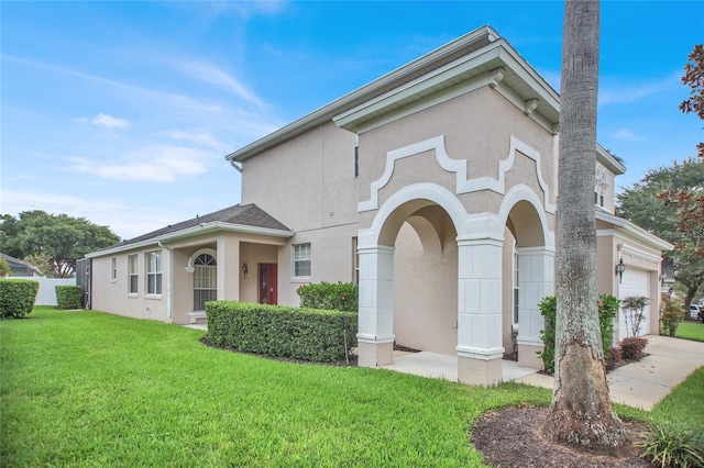 view of front facade featuring a front lawn, a garage, and stucco siding