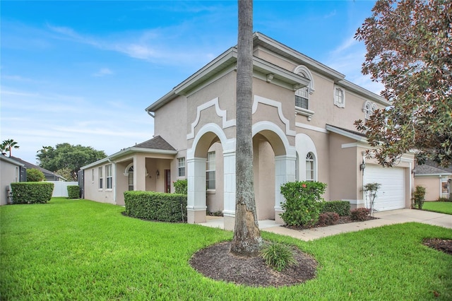 view of front of property with a front yard, an attached garage, driveway, and stucco siding