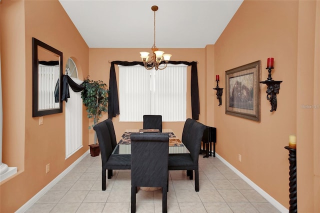 dining space with lofted ceiling, light tile patterned floors, baseboards, and a chandelier