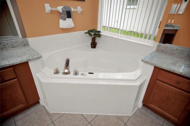 full bathroom featuring tile patterned flooring, a bath, and vanity