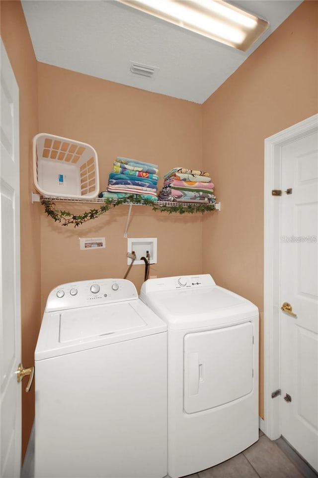 clothes washing area featuring visible vents, separate washer and dryer, and laundry area