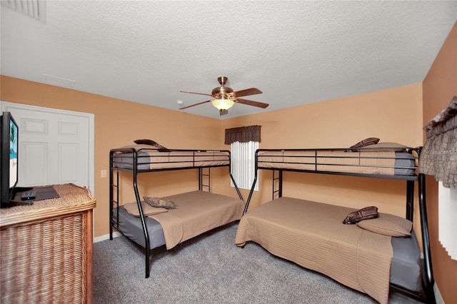 bedroom featuring carpet flooring, visible vents, a textured ceiling, and ceiling fan