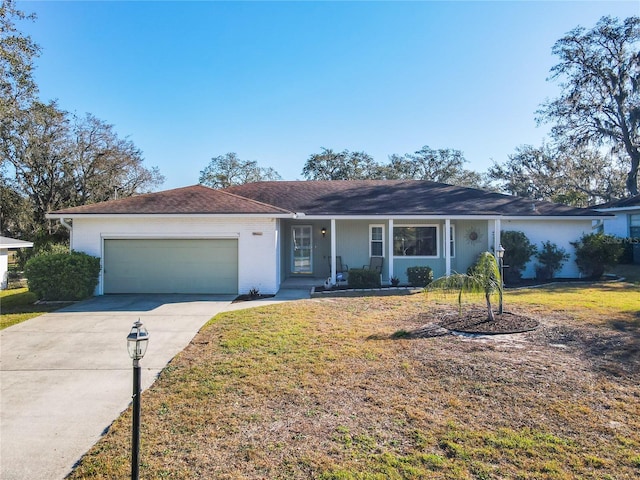 single story home featuring a front yard, concrete driveway, and a garage