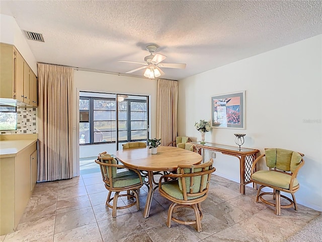 dining room with visible vents, a textured ceiling, and ceiling fan