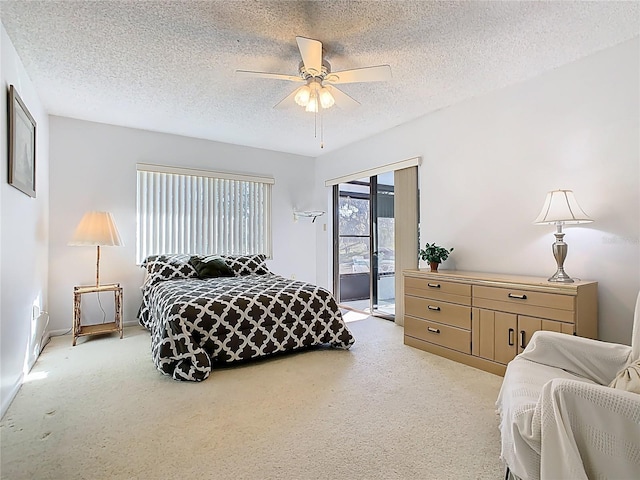 bedroom with access to exterior, a textured ceiling, light carpet, and a ceiling fan