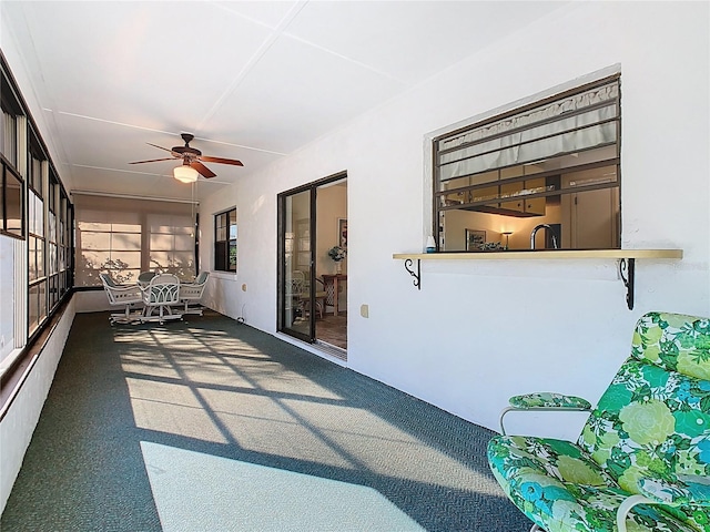 unfurnished sunroom featuring a ceiling fan