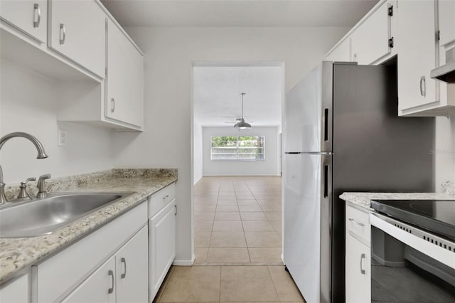 kitchen with light countertops, light tile patterned floors, electric range, white cabinets, and a sink