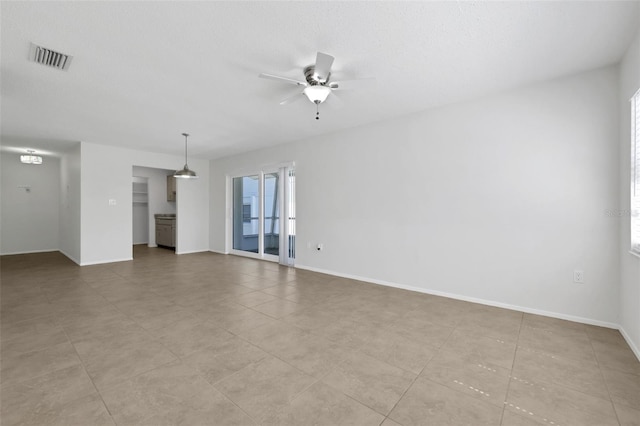 unfurnished living room with visible vents, baseboards, and a ceiling fan