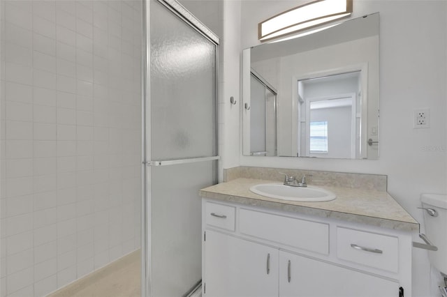 full bathroom featuring toilet, a stall shower, and vanity