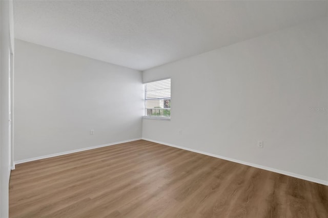 unfurnished room featuring baseboards and wood finished floors