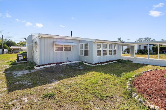 manufactured / mobile home with a carport and a front yard