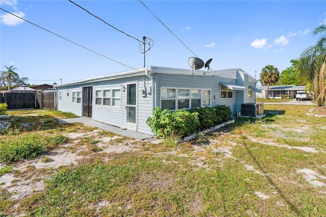 rear view of property featuring cooling unit and fence