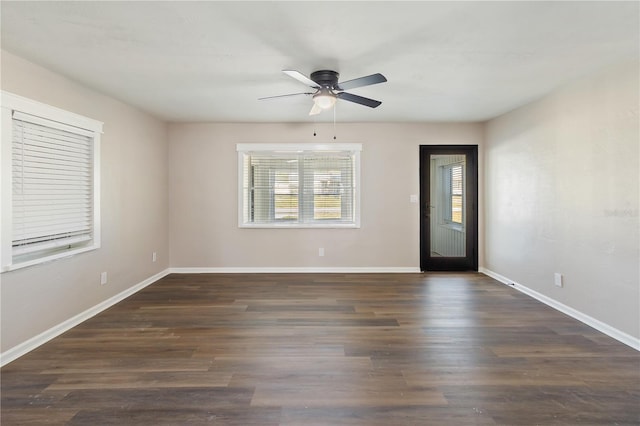 empty room with dark wood finished floors, baseboards, and ceiling fan