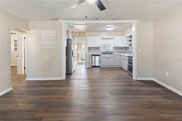 kitchen featuring a ceiling fan, a sink, open shelves, dark wood finished floors, and stainless steel appliances