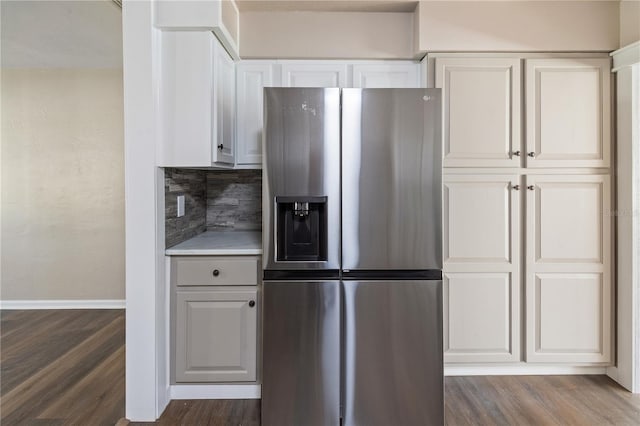 kitchen featuring backsplash, dark wood-style floors, stainless steel fridge with ice dispenser, and light countertops