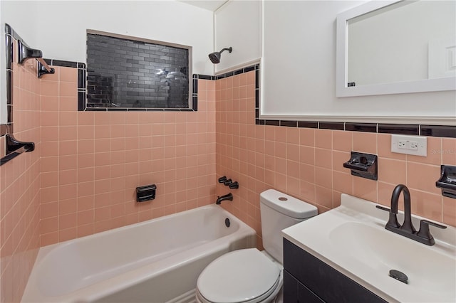 bathroom with vanity, toilet, tile walls, and washtub / shower combination