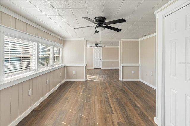 unfurnished room featuring a ceiling fan, visible vents, baseboards, ornamental molding, and dark wood-type flooring