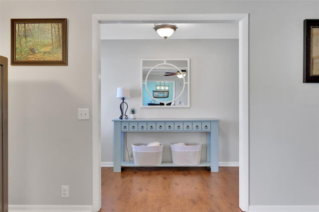 hallway featuring baseboards and wood finished floors