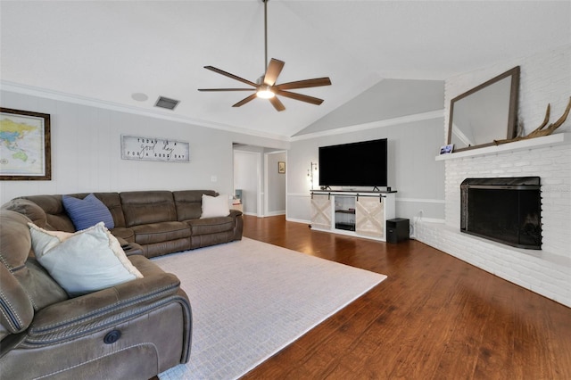 living area featuring visible vents, a ceiling fan, wood finished floors, a fireplace, and lofted ceiling