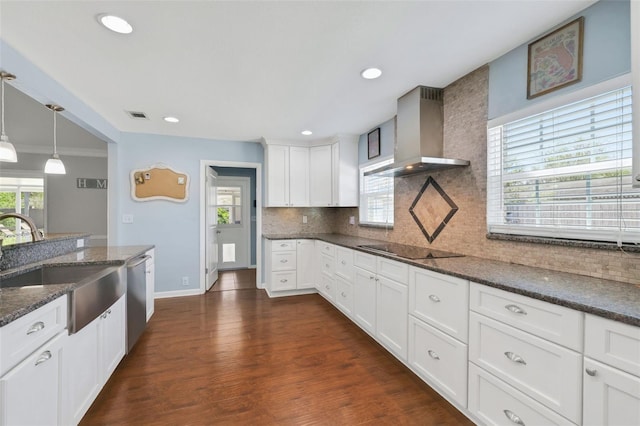 kitchen featuring a sink, tasteful backsplash, stainless steel dishwasher, wall chimney exhaust hood, and black electric cooktop