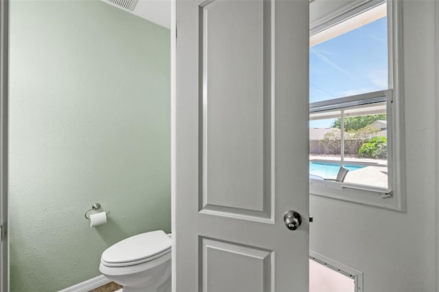 bathroom featuring toilet and baseboards