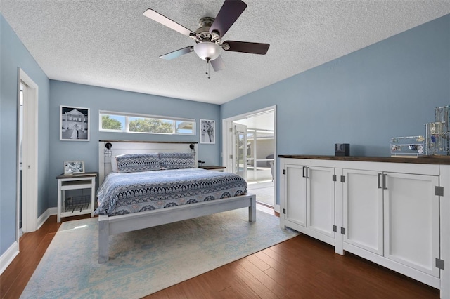 bedroom featuring ceiling fan, a textured ceiling, and dark wood-style floors