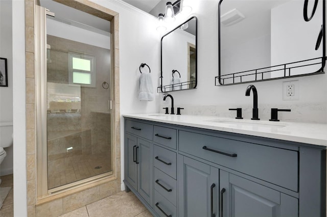 bathroom with double vanity, a stall shower, toilet, and a sink