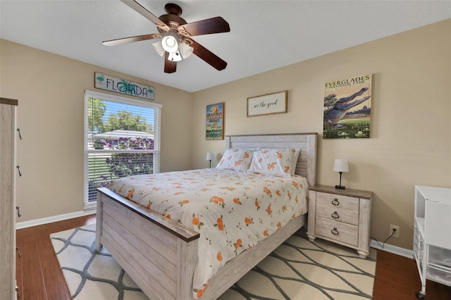 bedroom featuring wood finished floors, baseboards, and ceiling fan