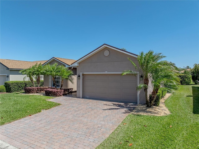 ranch-style home with driveway, stucco siding, a front yard, and an attached garage